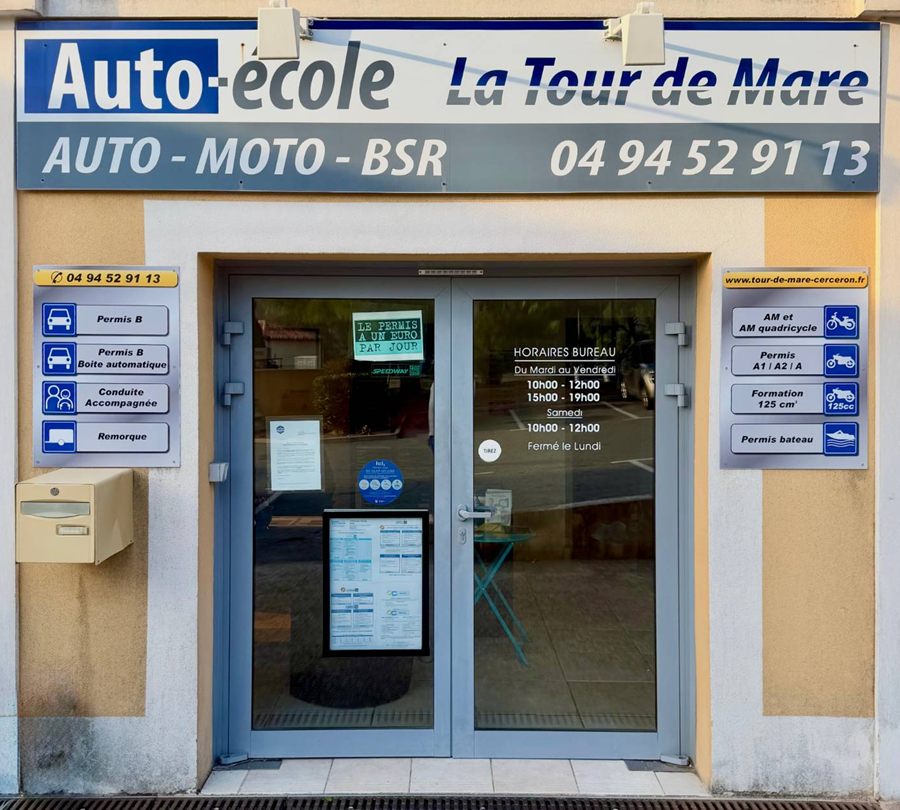 Façade de l'auto-école La Tour de Mare : enseigne Auto-école La Tour de Mare, Auto – Moto – BSR, 04 94 52 91 13, porte vitrée avec les horaires du bureau et panneaux des formations.